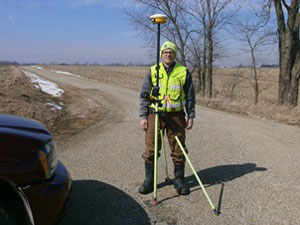 LE Land Surveying Services worker setting up an instrument